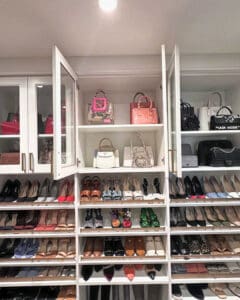 Primary closet glass cabinets with handbags on top shelves and heels lined up below, San Diego