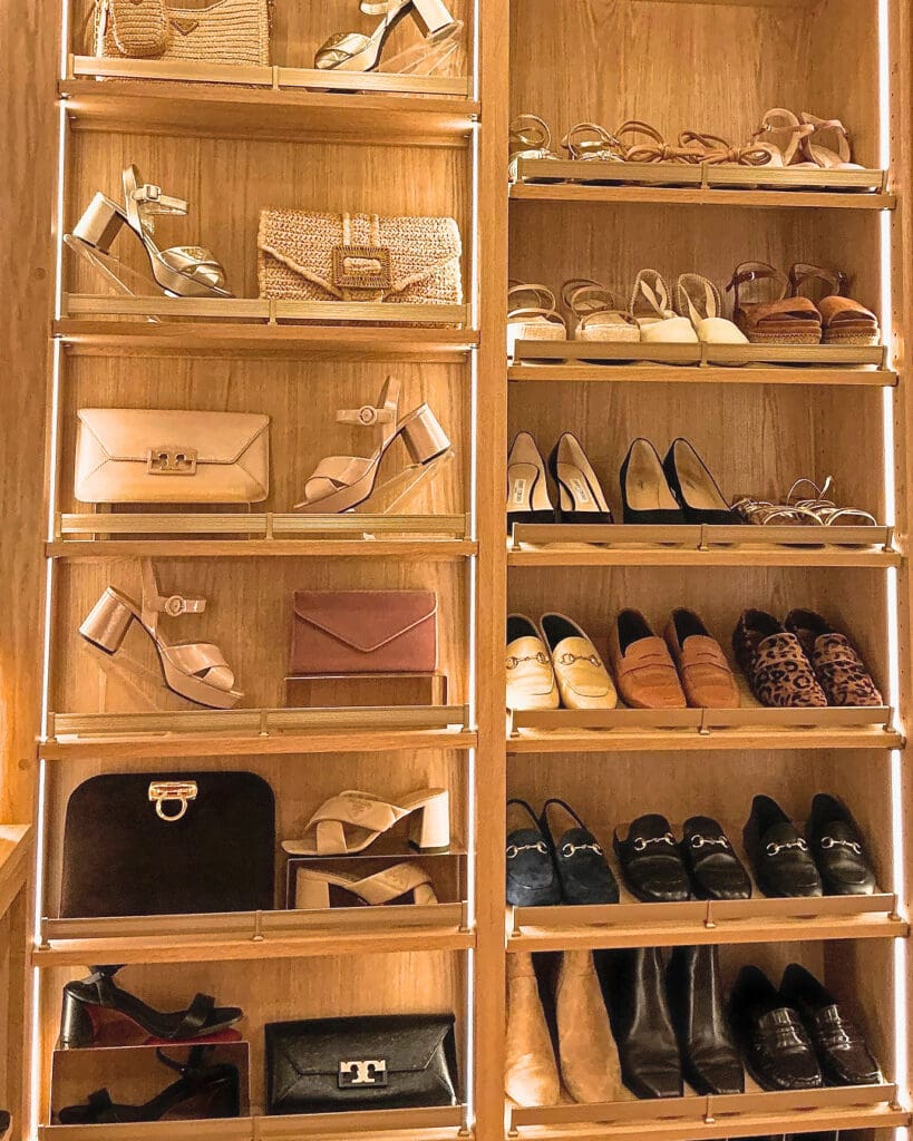 Same shoe wall after Simply Luxe organizing, with sandals, flats, boots and handbags lined up on lit shelves, San Diego