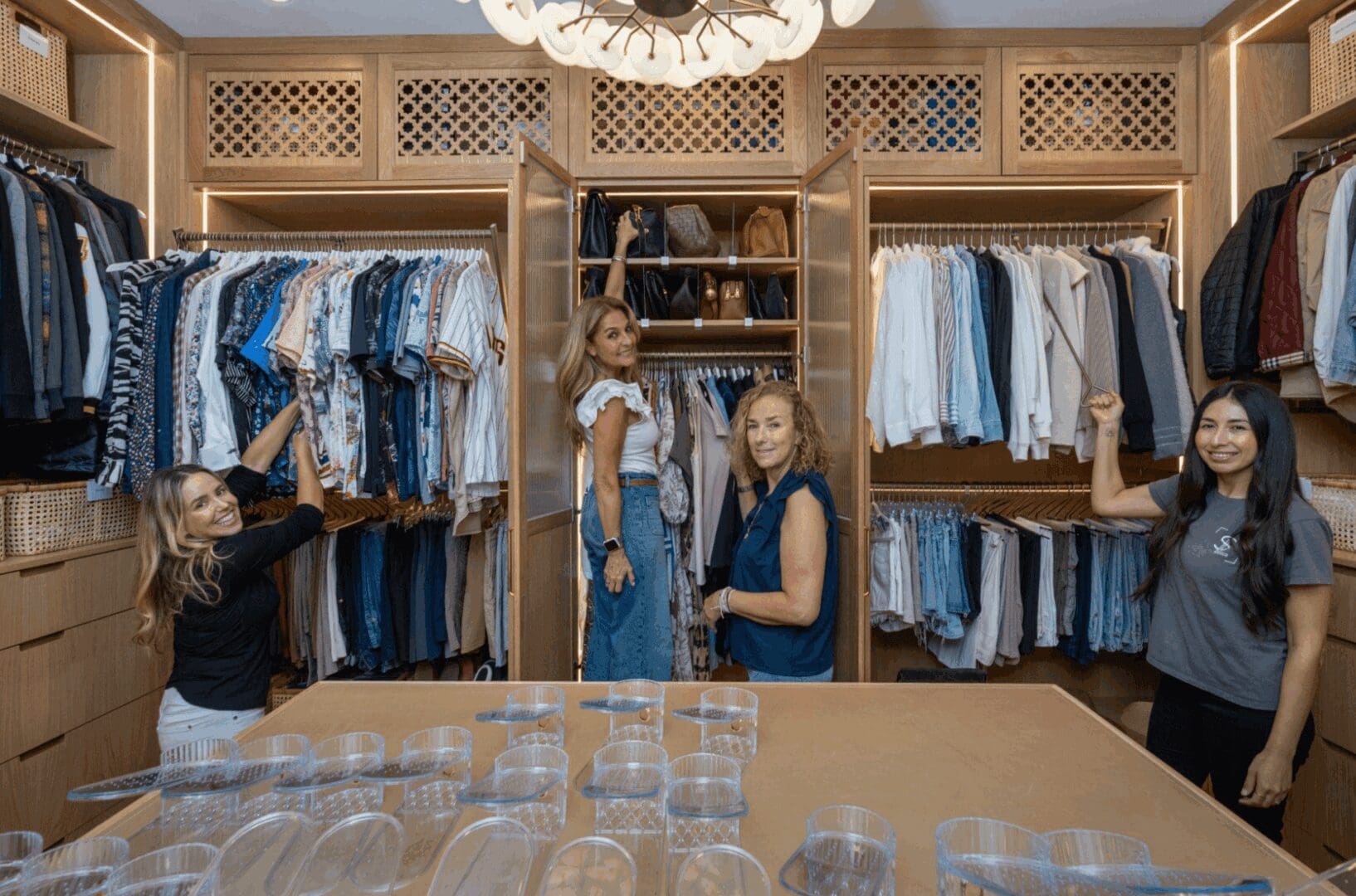 Women organizing clothes in walk-in closet.
