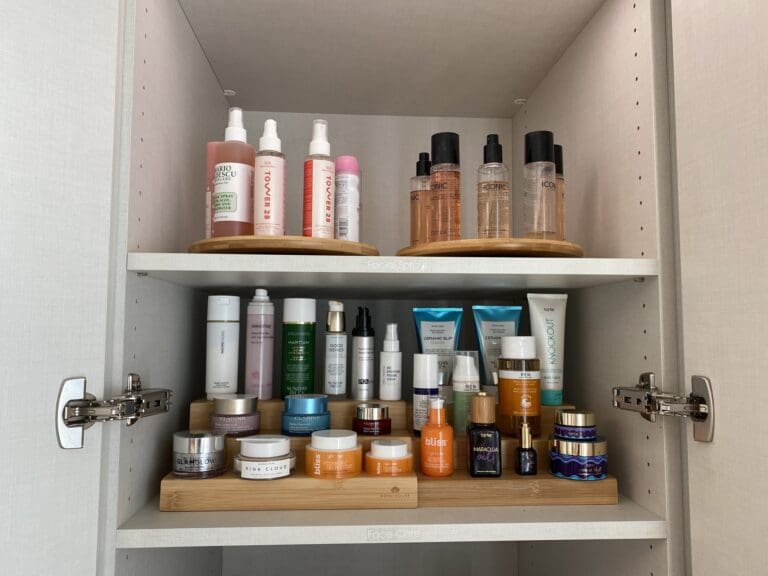 Skincare products grouped on wood risers inside a dressing room wardrobe in La Jolla