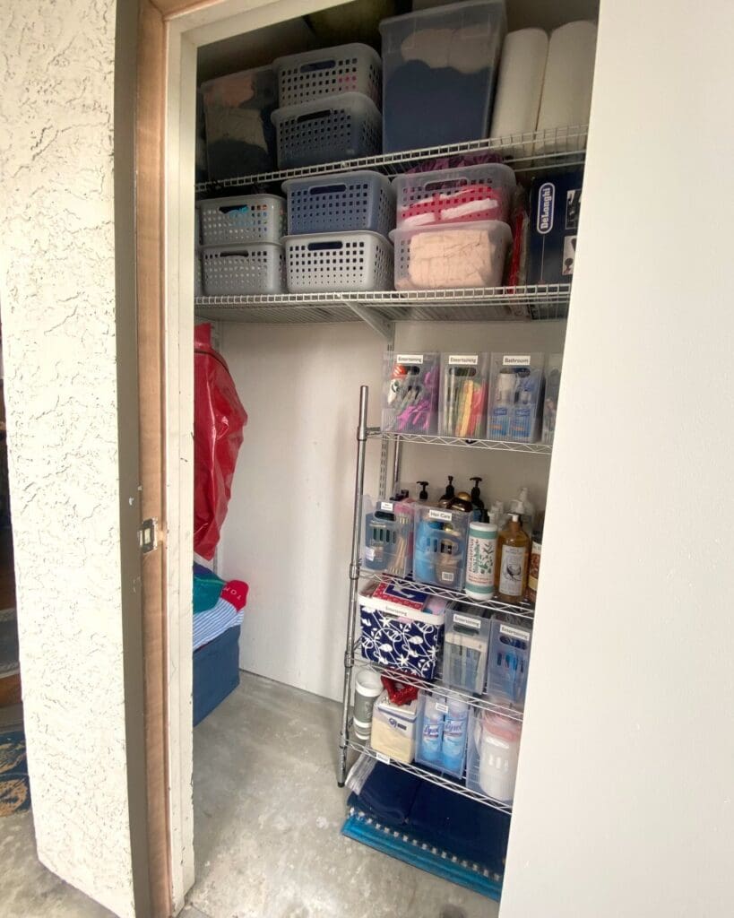Same storage closet after decluttering, with a metal wire rack, labeled bins and supplies sorted by type
