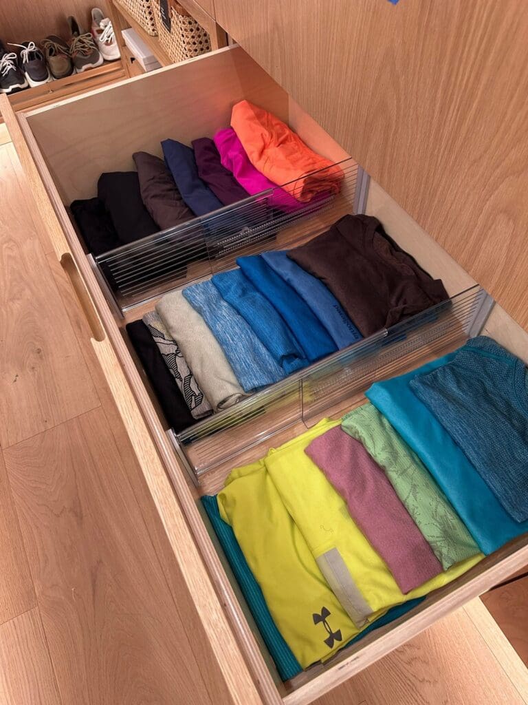 Closet drawer after organizing, with brightly colored tops file folded in clear acrylic dividers, San Diego
