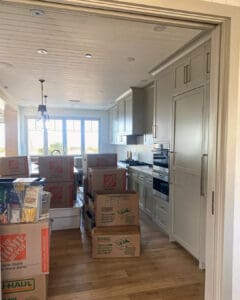 Moving boxes lined up through the kitchen during the unpack, Del Mar home