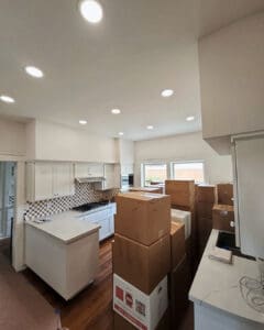 Kitchen mid unpack, with boxes on the counters and island being emptied, Orange County