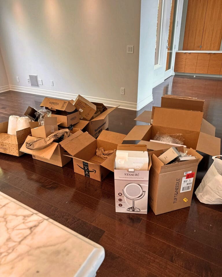 Empty vacation rental living area covered in opened delivery boxes before setup, San Diego