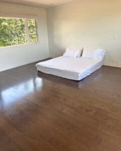 Empty vacation rental bedroom with only a mattress on the floor before furniture delivery, San Diego
