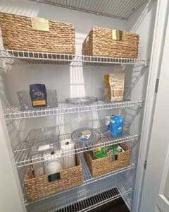 Vacation rental pantry stocked and ready, with woven baskets, coffee and snacks on wire shelves, San Diego