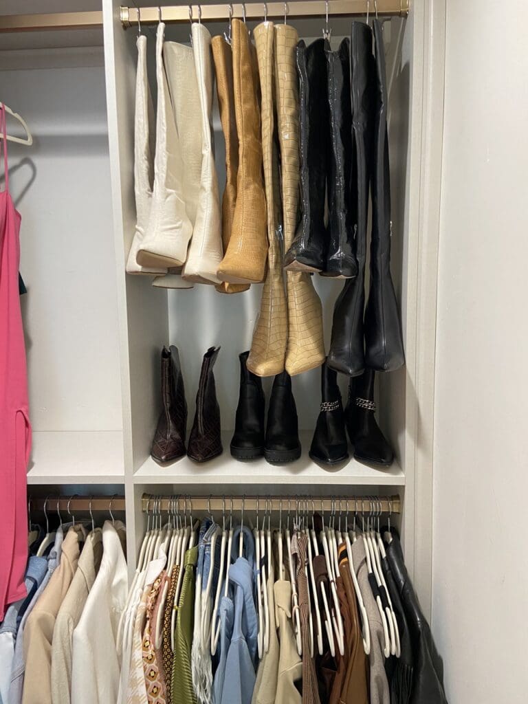 Jackets hung by color above a row of boots in an organized La Jolla closet