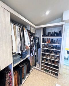 Walk in closet after unpacking, with clothes hung by type and shoes lined up on shelves, Del Mar
