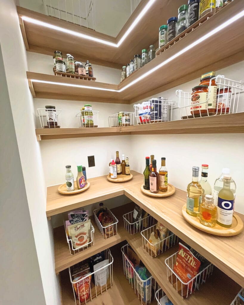 Same walk-in pantry after Simply Luxe organizing, with wire baskets, turntables and jars zoned shelf by shelf, San Diego